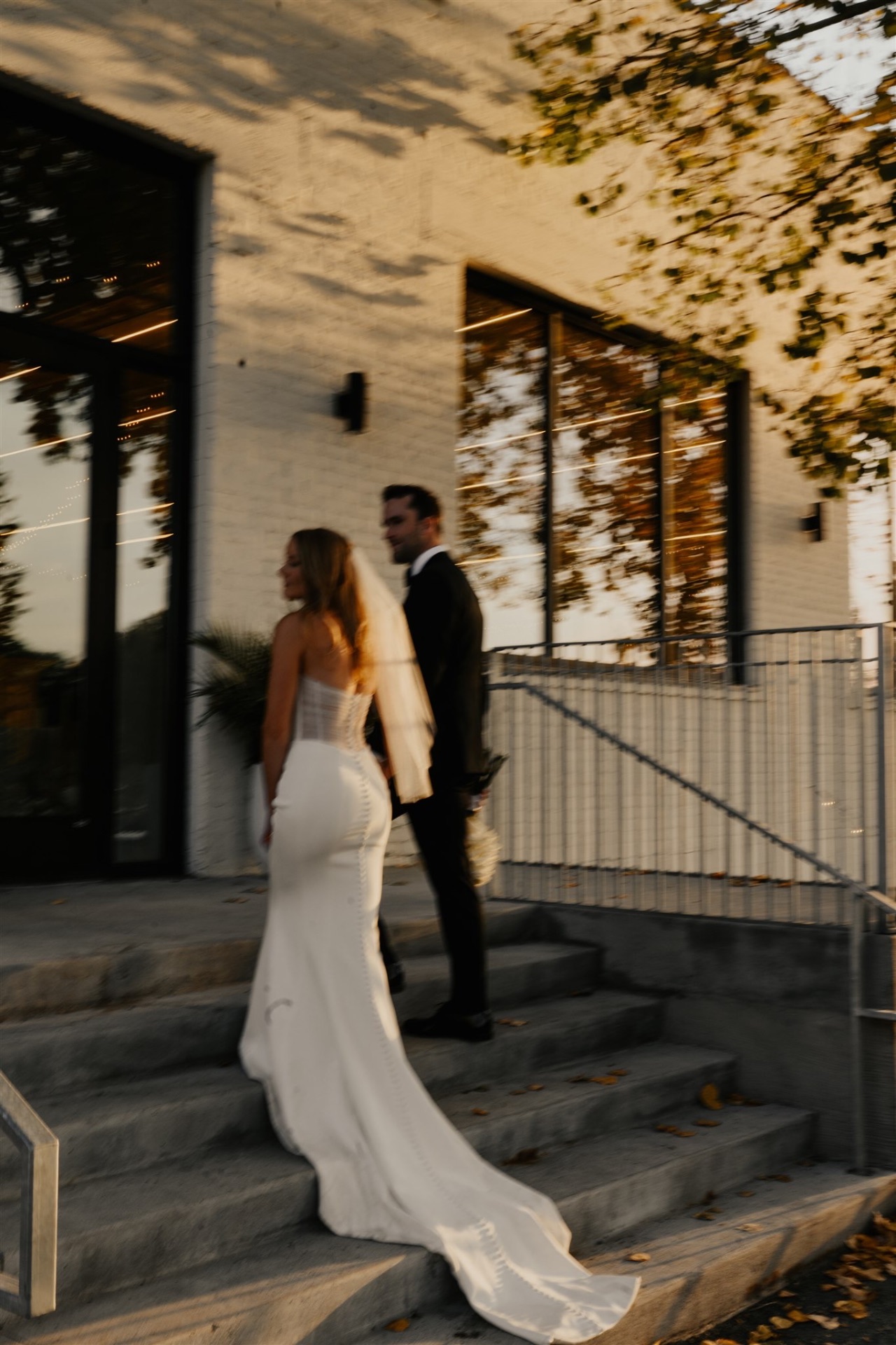 Bride and groom walking up sunlit steps